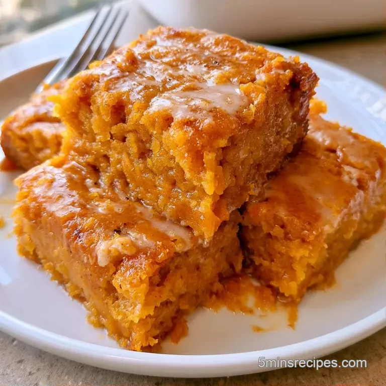 A golden-orange cake slice topped with a dollop of white cream and a sprinkle of cinnamon on a rustic linen napkin.
